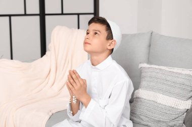 Little Muslim boy praying at home