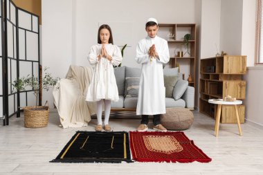 Little Muslim children praying at home