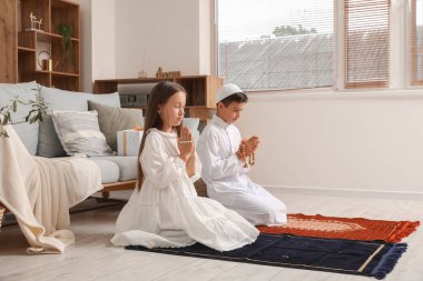 Little Muslim children praying at home