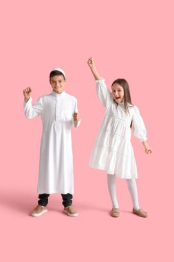 Happy little Muslim children on pink background