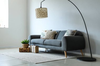 Grey sofa with soft cushions in light living room