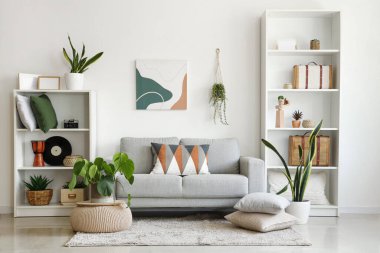 Stylish grey sofa with soft cushions in interior of modern living room