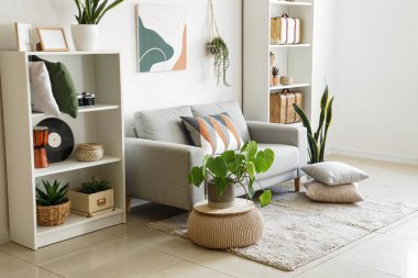 Stylish grey sofa with soft cushions in interior of modern living room