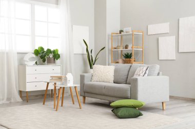 Grey sofa with cushions in interior of modern living room
