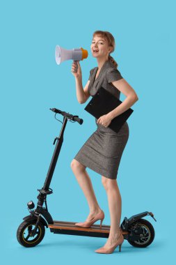 Portrait of young businesswoman with kick scooter, clipboard and megaphone on blue background