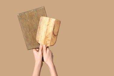 Bej arka planda tahta kesme tahtaları olan kadın eller