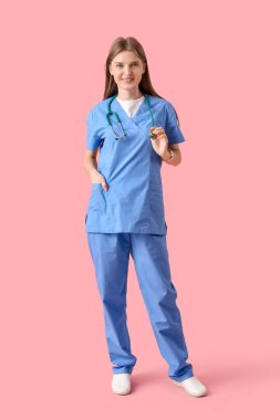 Beautiful doctor with stethoscope on pink background