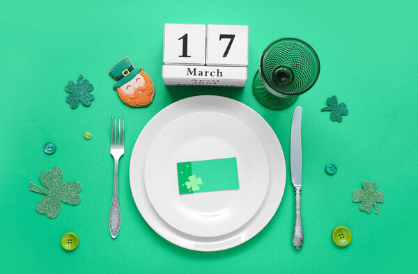 Beautiful table setting for St. Patrick's Day celebration on green background
