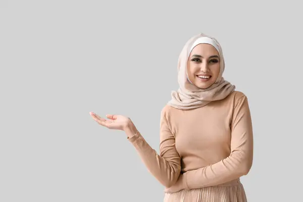 Young Muslim Woman Showing Something Light Background Islamic New Year — Stockfoto