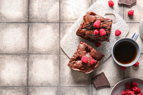 Üzerinde ahududu çikolatalı browni olan tahta gri fayans masasında.