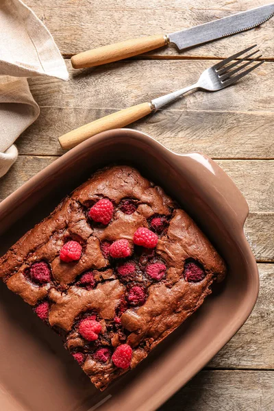 Ahududulu çikolatalı brownie ile ahşap masada pişirme tabağı