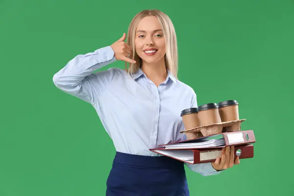 Female secretary with coffee cups and folders showing \
