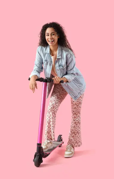 Young African American Woman Riding Kick Scooter Pink Background — Stockfoto