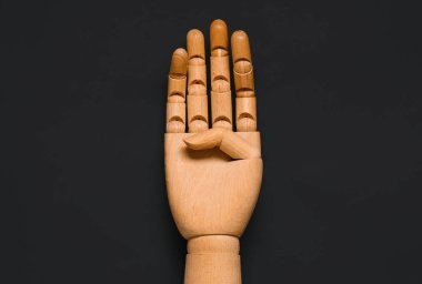 Wooden hand on dark background, closeup. Domestic violence concept