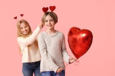 Little children with hearts and balloon on pink background. Valentine's Day celebration