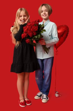 Little children with roses and balloon on red background. Valentine's Day celebration