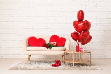 Interior of festive living room with white sofa, coffee table and decorations for Valentine's Day celebration