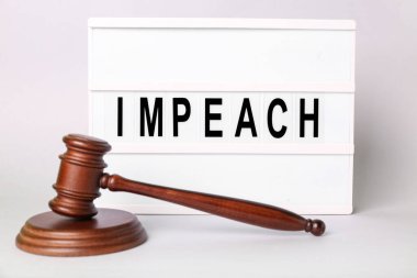 Judge gavel and board with word IMPEACH on white background