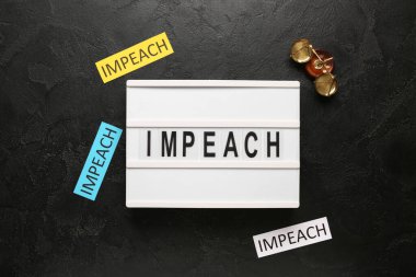 Board with words IMPEACH and scales of justice on black grunge background