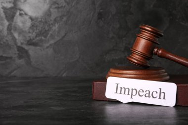 Word IMPEACH, judge gavel and law book on black grunge background