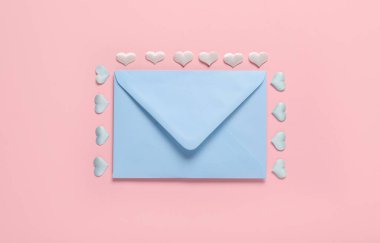 Composition with blue envelope and hearts on pink background. Valentine's Day celebration