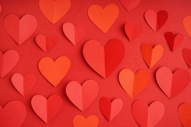 Kırmızı arka planda kağıt kalpler. Sevgililer Günü kutlaması