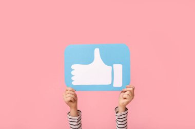 Little girl with like icon on pink background