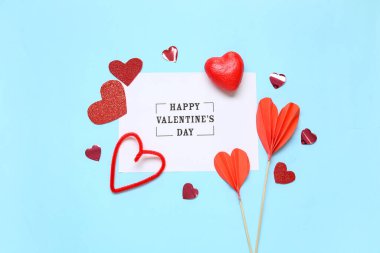 Yazılı kart Mutlu VALENTINE Günü ve mavi arkaplanda kalp şekilli dekor
