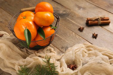 Bir sepet tarçınlı tatlı mandalina ve ahşap arka planda yıldız anason.