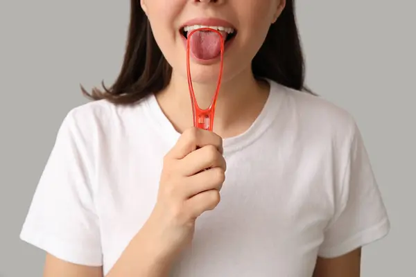 Young Woman Using Tongue Scraper Light Background Closeup — Zdjęcie stockowe