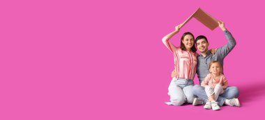 Happy family with cardboard in shape of roof dreaming about their new house on purple background with space for text