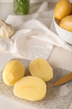 Hafif arka planda soyulmuş patatesli tahta