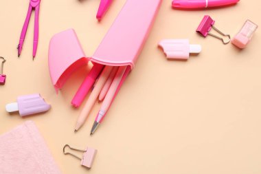 Bej arka planda okul kırtasiyesi olan pembe kalem çantası.