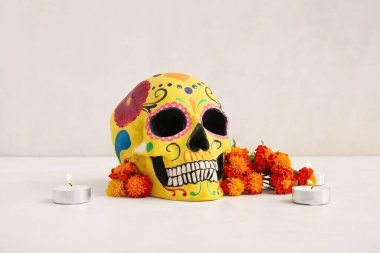 Kadife çiçekli mumlar ve beyaz arka planda boyalı kafatası. Meksika Ölüler Günü 'nün Kutlaması (El Dia de Muertos)