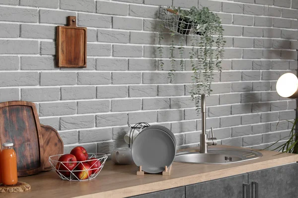 Modern mutfakta lavabosu, elması ve tabağı olan ahşap tezgah.