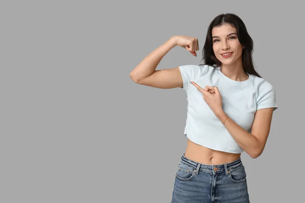 Young Woman Flexing Muscles Grey Background Feminism Concept — ストック写真