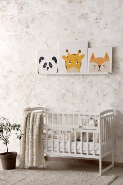 Bebek yatağı ve resimlerle dolu bir çocuk odası.