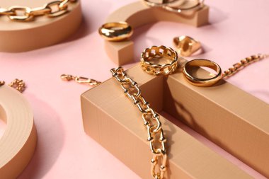 Pembe arka planda güzel mücevherleri olan dekoratif podyumlar.