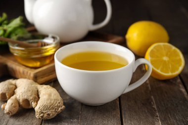 Bir fincan zencefilli çay ve bal, ahşap zemin üzerinde.