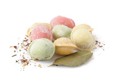 Beyaz zemin üzerinde baharat ve defne yaprağı olan renkli çiğ hamur köfteleri.