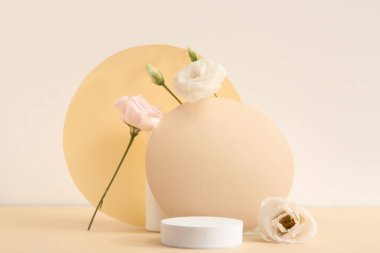Composition with beautiful eustoma flowers and plaster podium on beige background