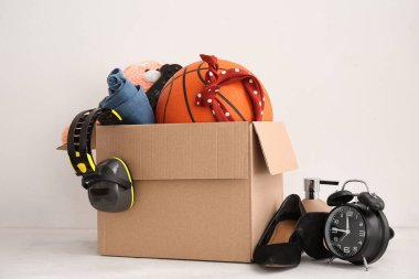 Bahçe satışı için istenmeyen eşyalar bej duvarın yanındaki masada.