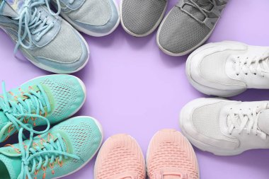 Frame made of different stylish sneakers on purple background