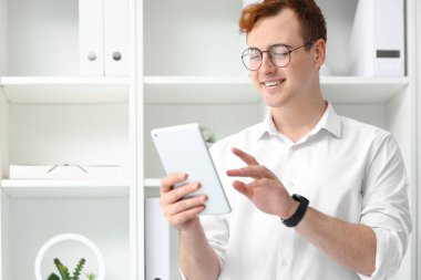 Young businessman working with tablet computer in office clipart