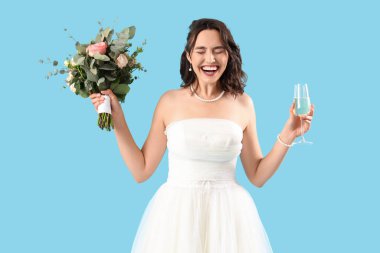 Beautiful bride with wedding bouquet and champagne on blue background