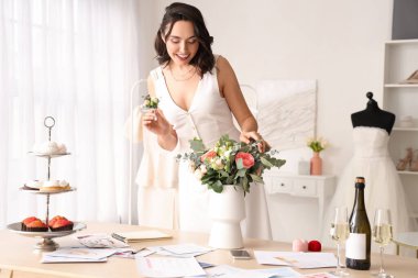 Young woman with bouquet planning her wedding in office