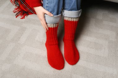 Woman in red knitted socks at home