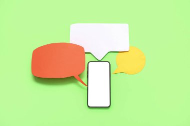 Mobile phone with blank screen and empty speech bubbles on green background