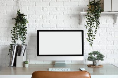 Boş bilgisayar monitörü ve açık ofisteki bitkiler.