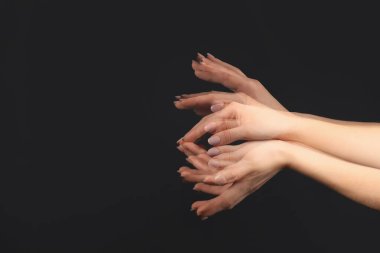 Stroboscopic photo of female hands moving on dark background